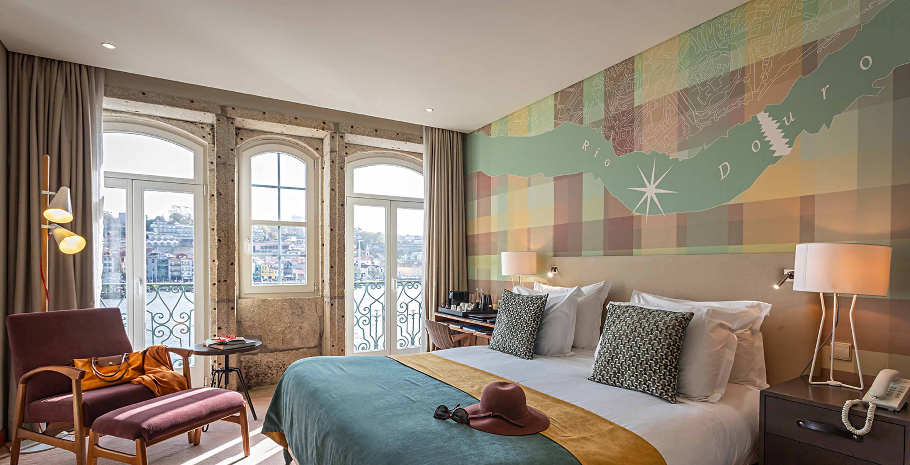 The Vintage River View Balcony room at Pestana Vintage Porto has a large window with balcony and view of the Douro River