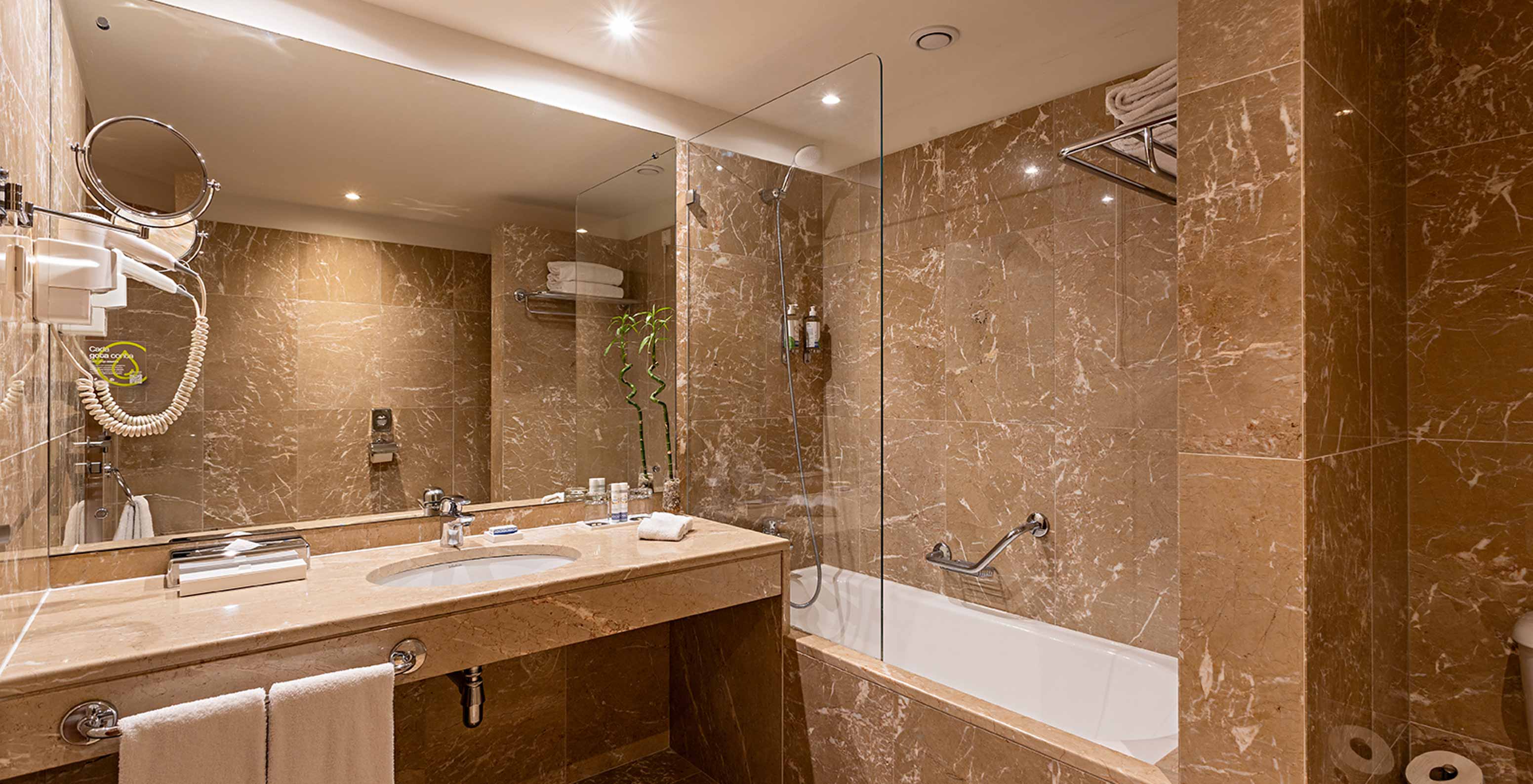 The Grand View Suite at Pestana Vintage Porto has a bathroom with bathtub with shower, sink and a large mirror
