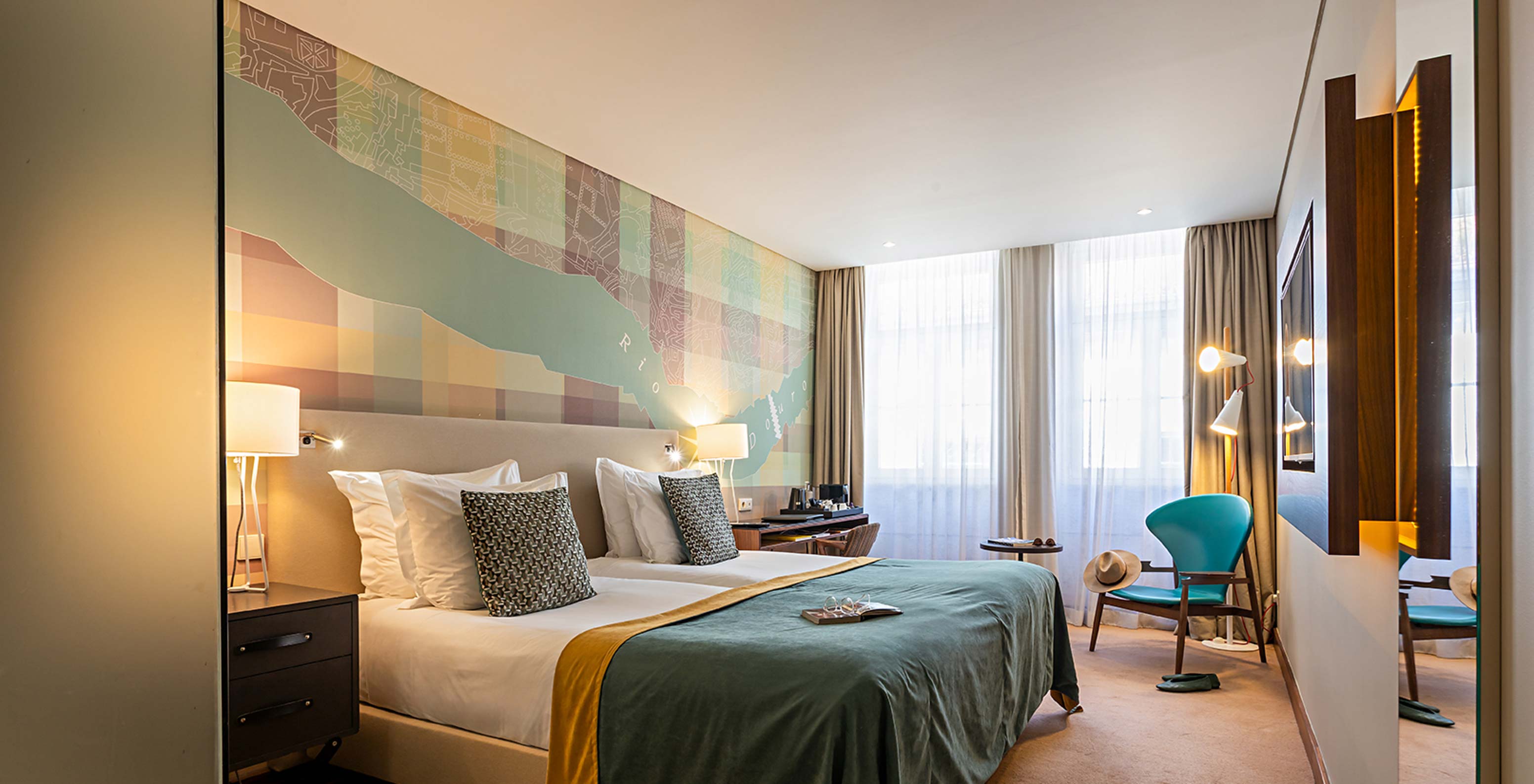 The Superior room at Pestana Vintage Porto has a double bed, a desk and wallpaper with images