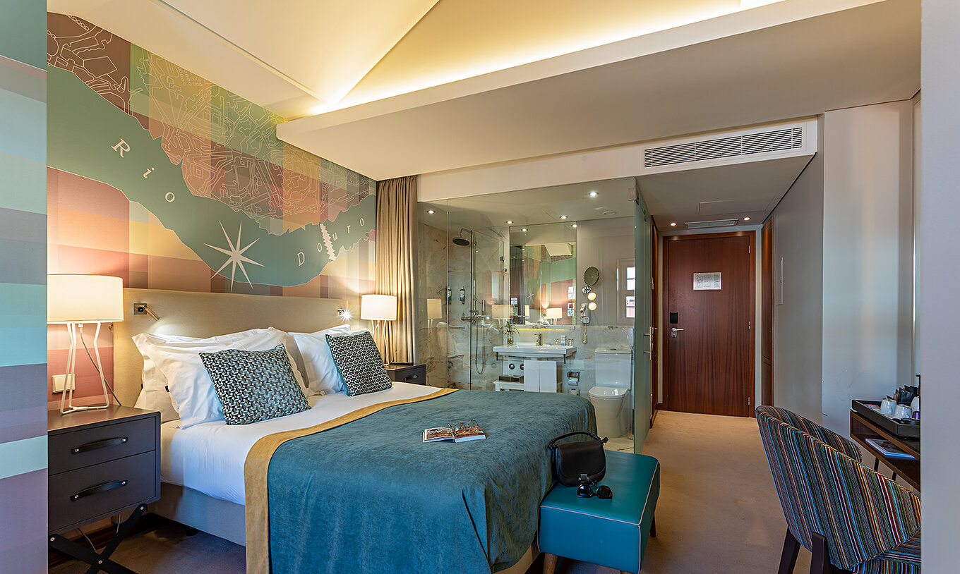 The Classic at Pestana Vintage Porto has a double bed with a blue cover and a desk with a chair