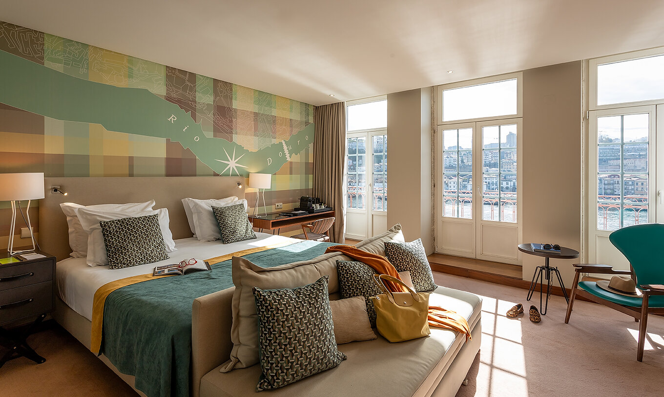 The Vintage Grand View Balcony at Pestana Vintage Porto has a double bed and windows with a view of the Porto riverside