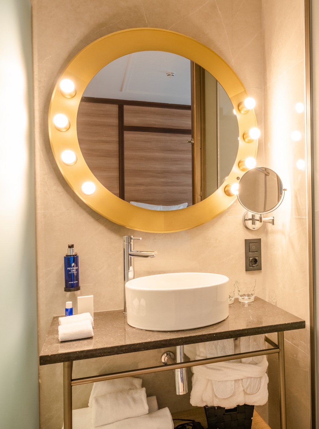 The Cozy Room at Pestana CR7 Gran Vía Madrid has a bathroom with a round mirror with lights
