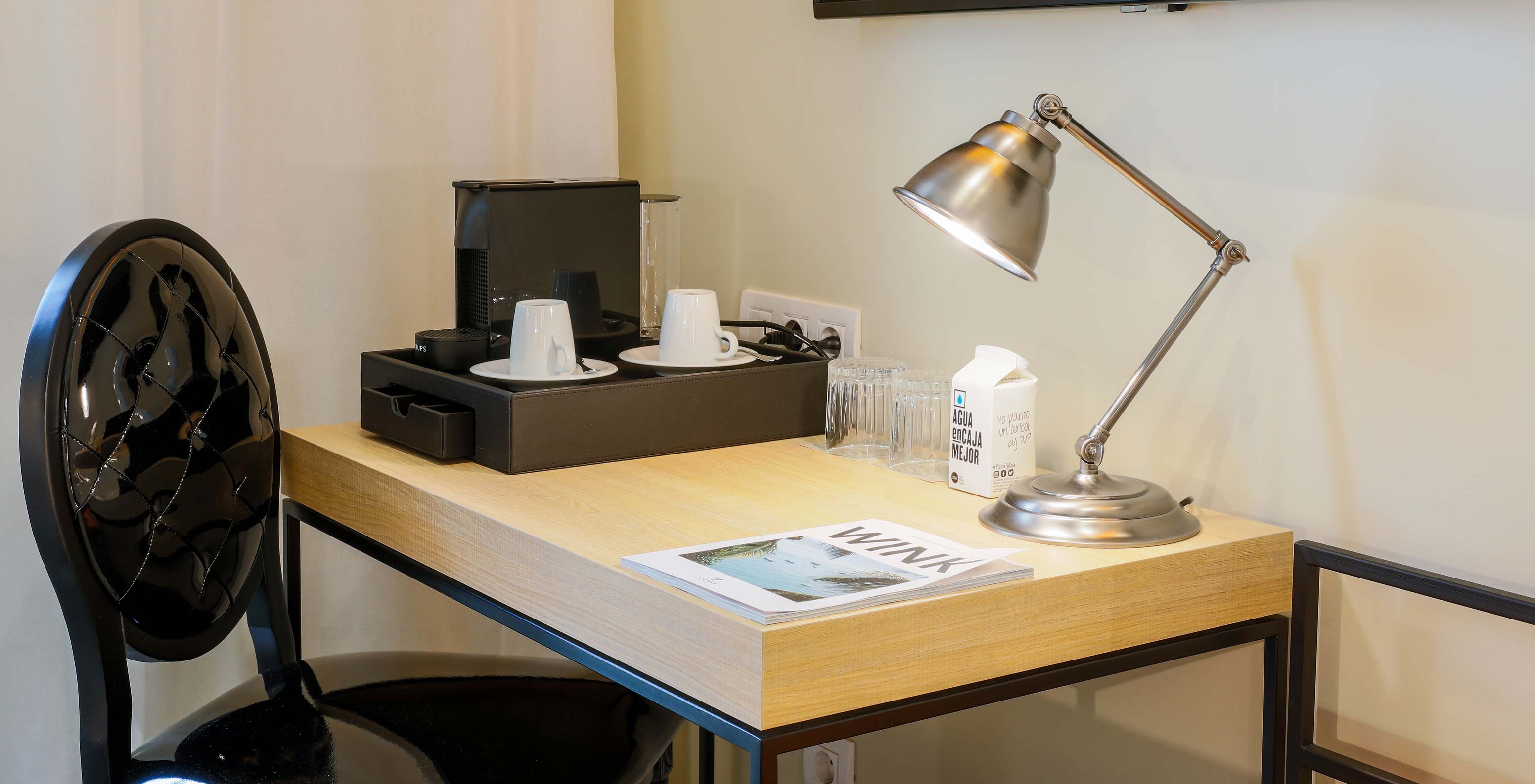 The classic room at Pestana Collection Plaza Mayor has a desk, with a Nespresso coffee machine, a lamp, and a black chair