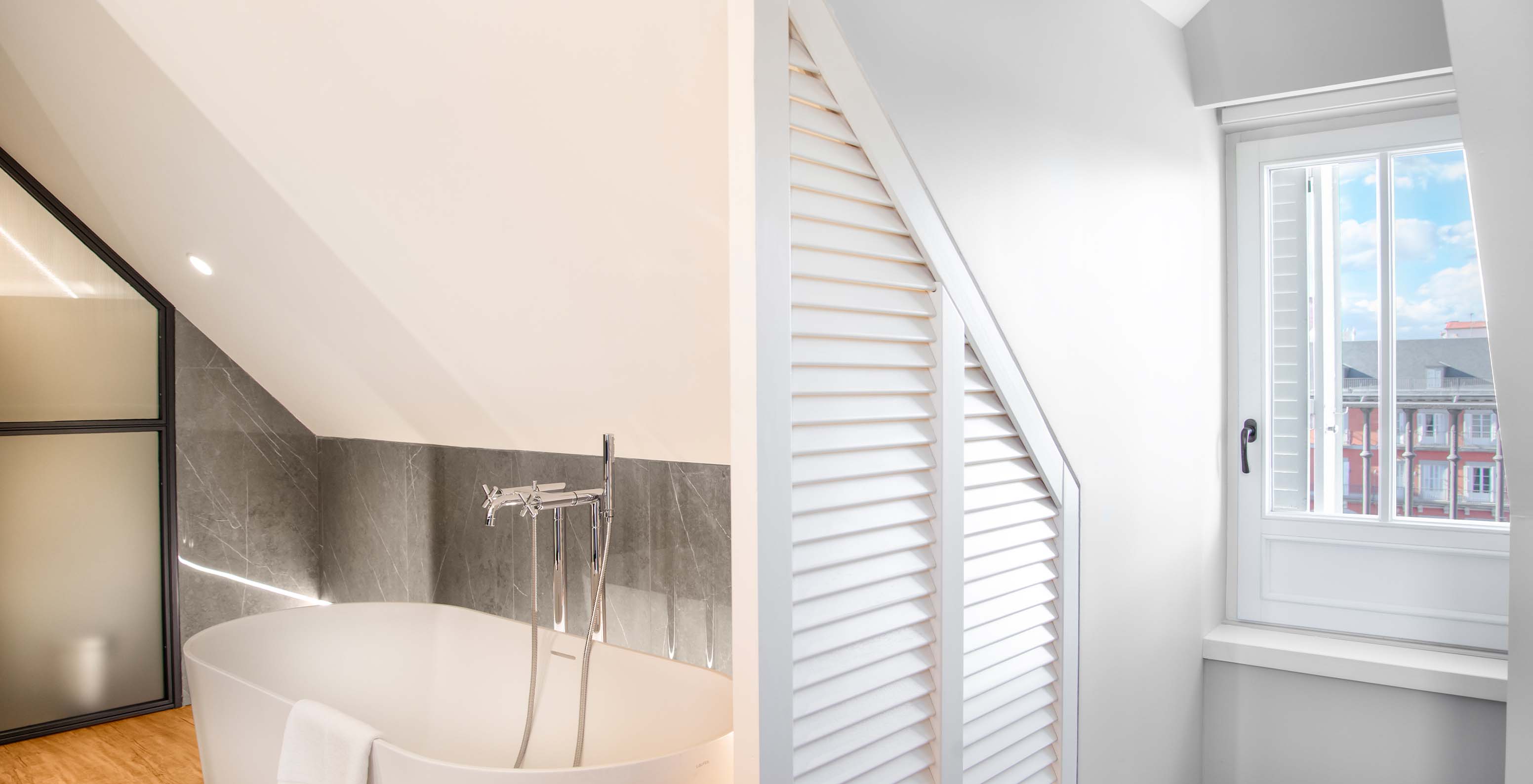 The Suite Plaza Mayor at Pestana Plaza Mayor Madrid has a bathroom with bathtub and window with a view of Plaza Mayor