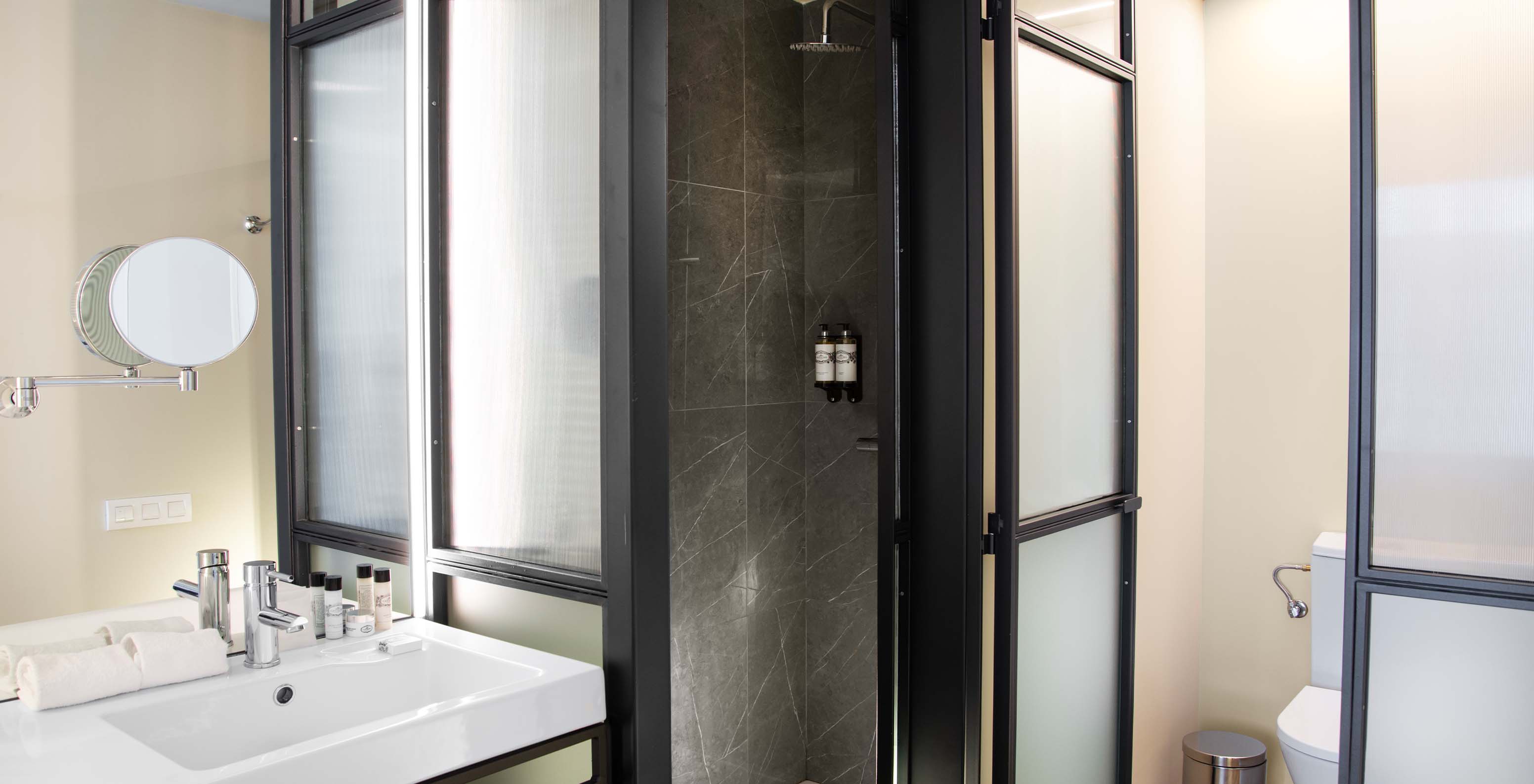 The Superior Room at Pestana Plaza Mayor Madrid has a bathroom with sink, mirror, shower and toilet