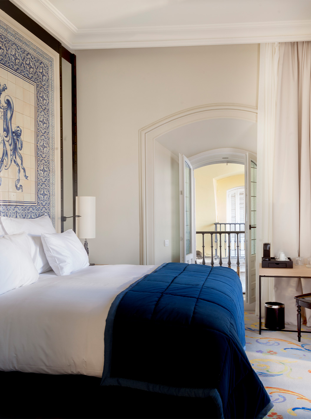 The Suite Plaza Mayor at Pestana Plaza Mayor Madrid has a double bed and a headboard with blue and white tiles