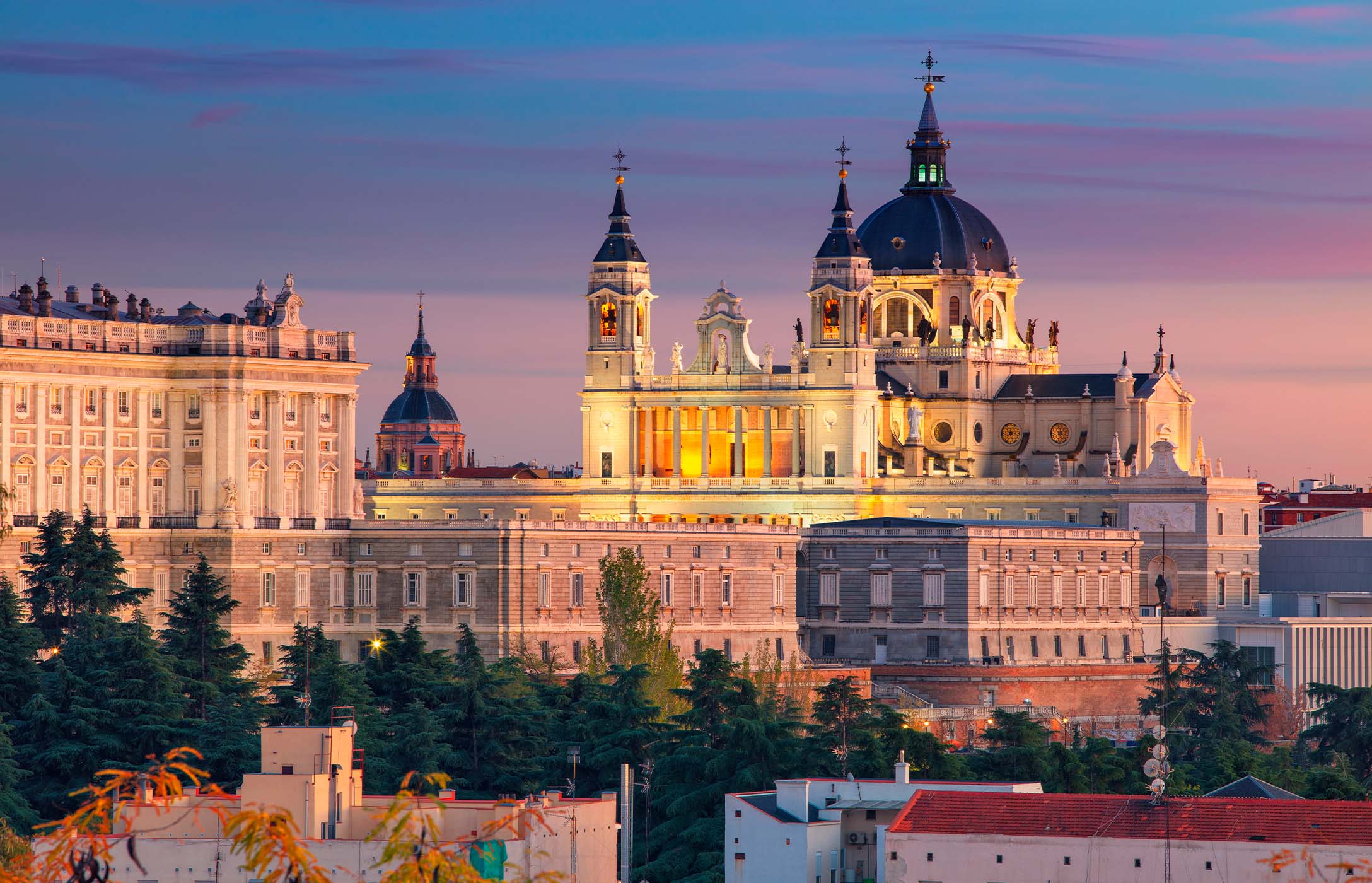 The imposing Madrid Cathedral, with its dome, stands out next to the Royal Palace of Madrid, in Spain