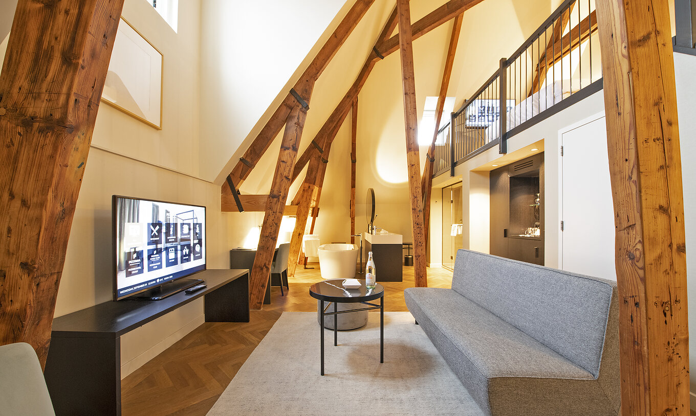 Clock Tower Suite at Pestana Amsterdam Riverside has a living room with sofa, coffee table, and TV