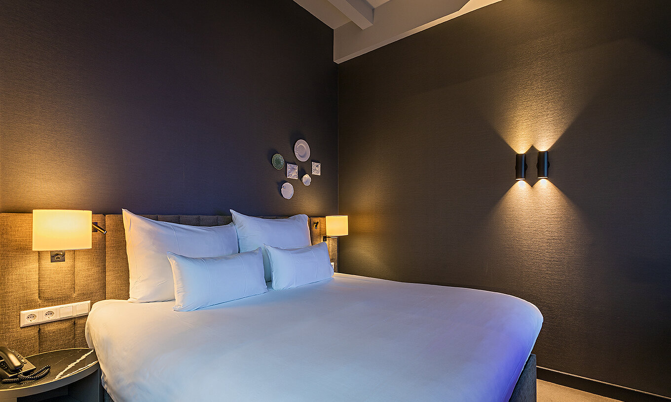 Loft room at Pestana Amsterdam Riverside has a double bed, with bedside table and lamp