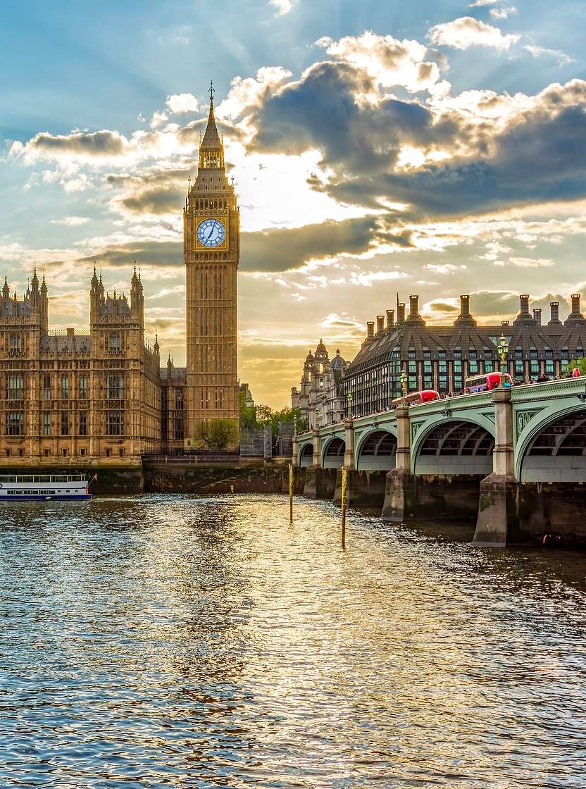Panoramic view of the Palace of Westminster, in London, next to the iconic Big Ben, with the River Thames in the foreground