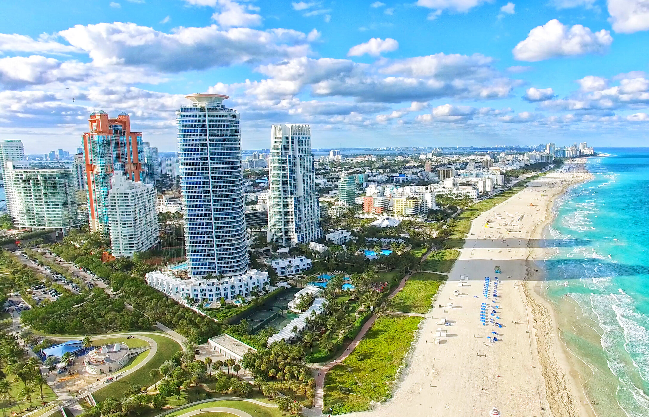 View over the white sandy beach in South Beach, with crystal-clear waters and tall buildings parallel to the beach