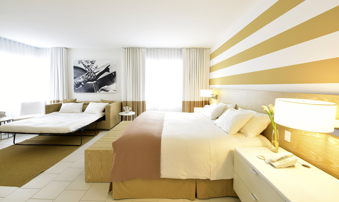 The Pestana Deluxe with Sofa Bed at Pestana Miami South Beach has a double bed, sofa bed, bedside table and lamp
