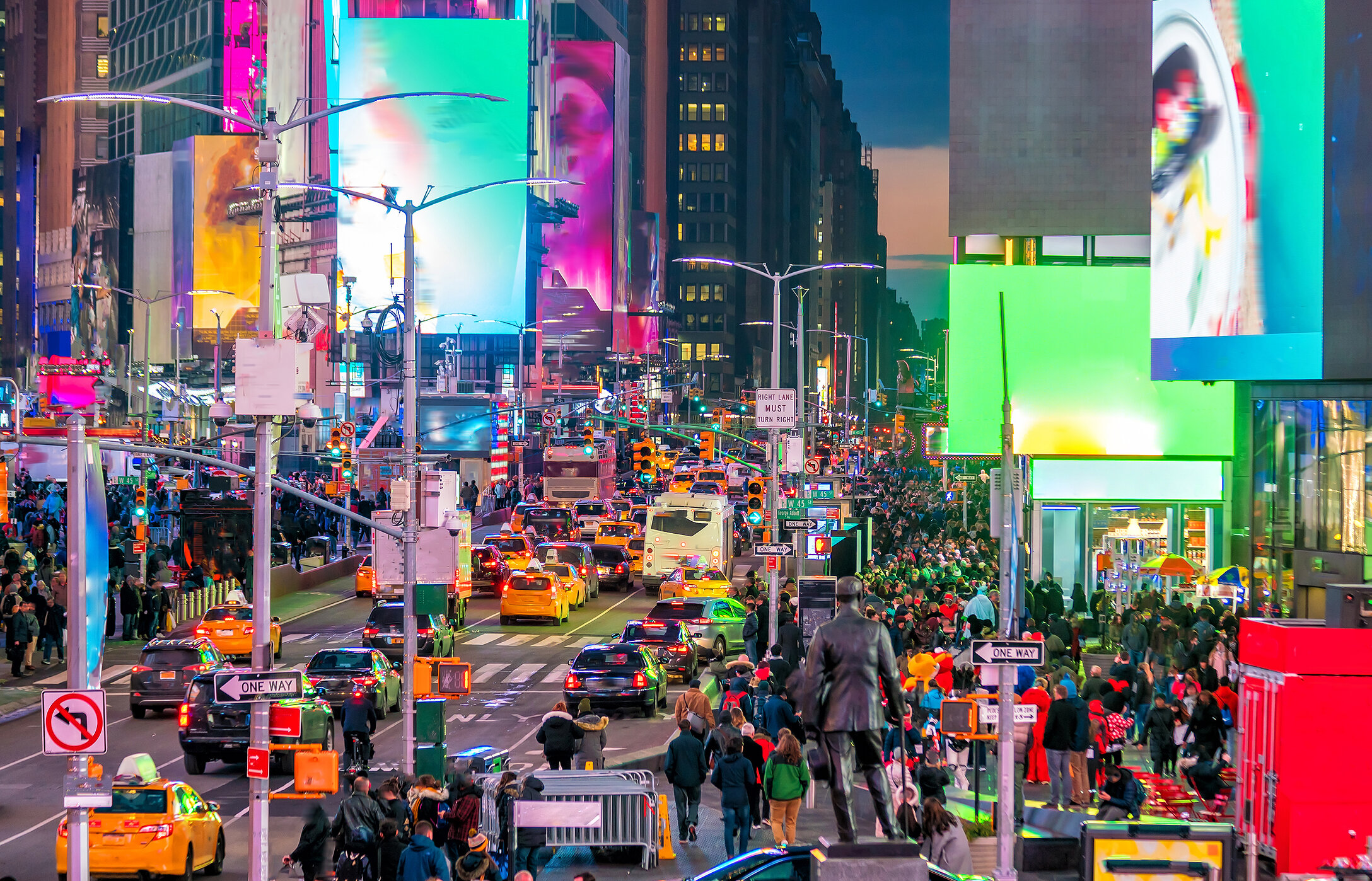 Panoramic view of Times Square, a crossroads with advertising billboards, crowds of tourists, and skyscrapers