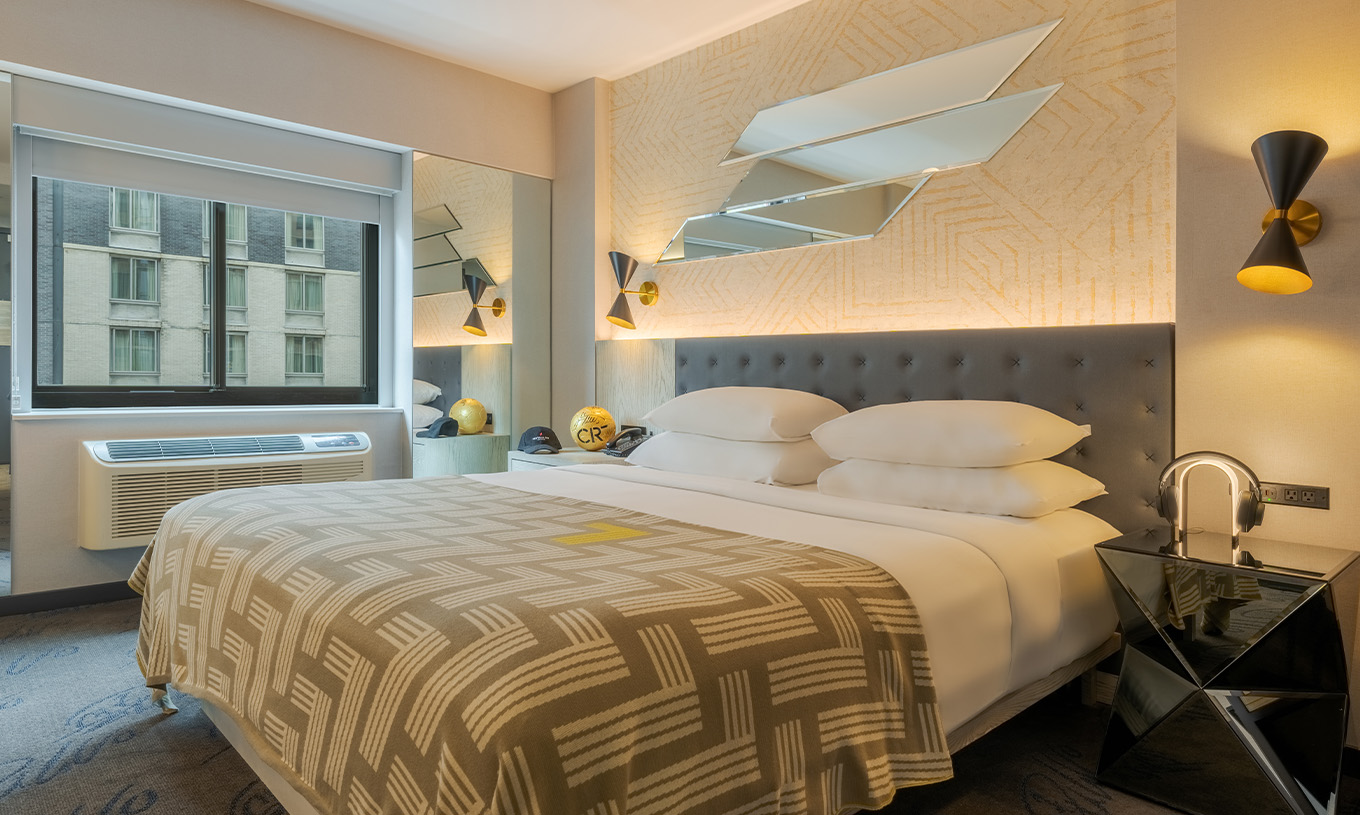The Comfort at Pestana CR7 Times Square has a double bed with a bedspread with the number seven and a window