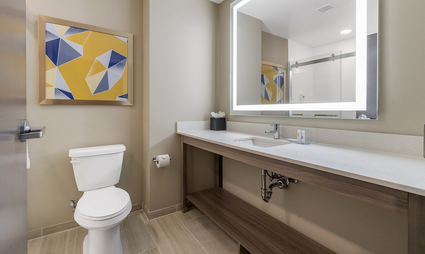 The King Master Suite at Pestana Orlando Suites Lake Buena Vista features a bathroom with a sink, mirror, and toilet
