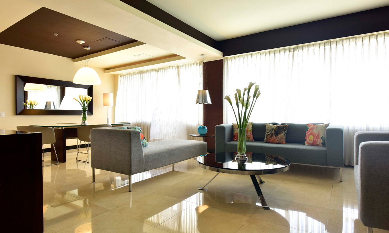 The Presidential Suite at Pestana Caracas has a spacious living room with three comfortable sofas and a dining table