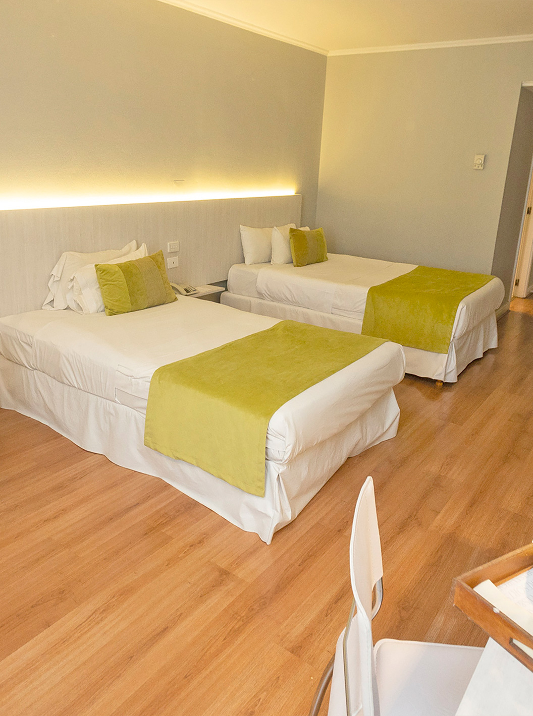 La habitación Twin superior del Pestana Buenos Aires cuenta con dos camas individuales, mesita, silla y televisión