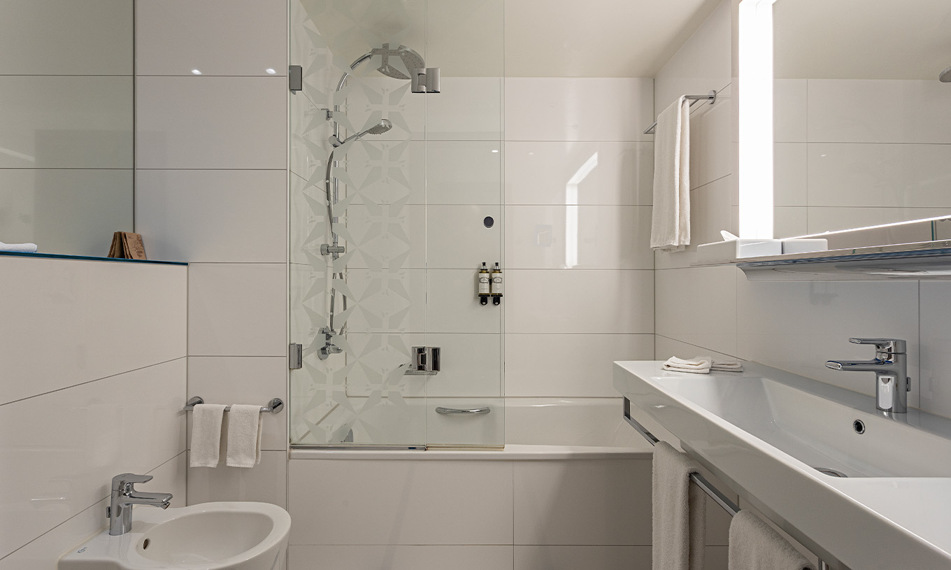 El cuarto Grand Deluxe del Pestana Berlin Tiergarten tiene baño con bañera y ducha, y un lavabo