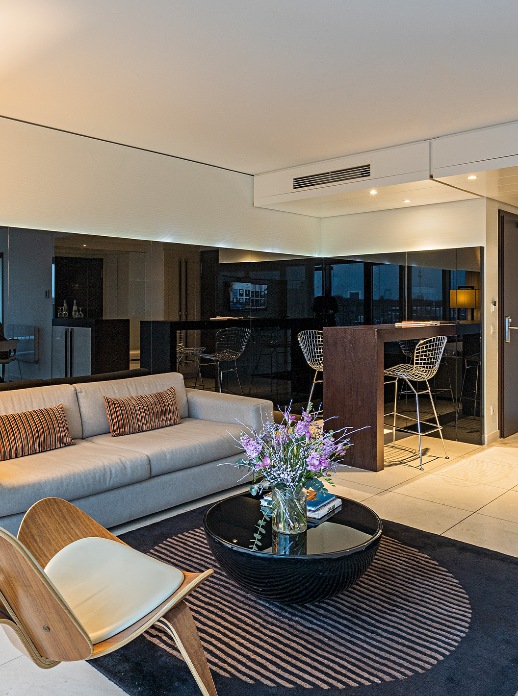 La Suite Panorámica del Pestana Berlin Tiergarten tiene sofá con lámpara, mesa de centro y un balcón con sillas