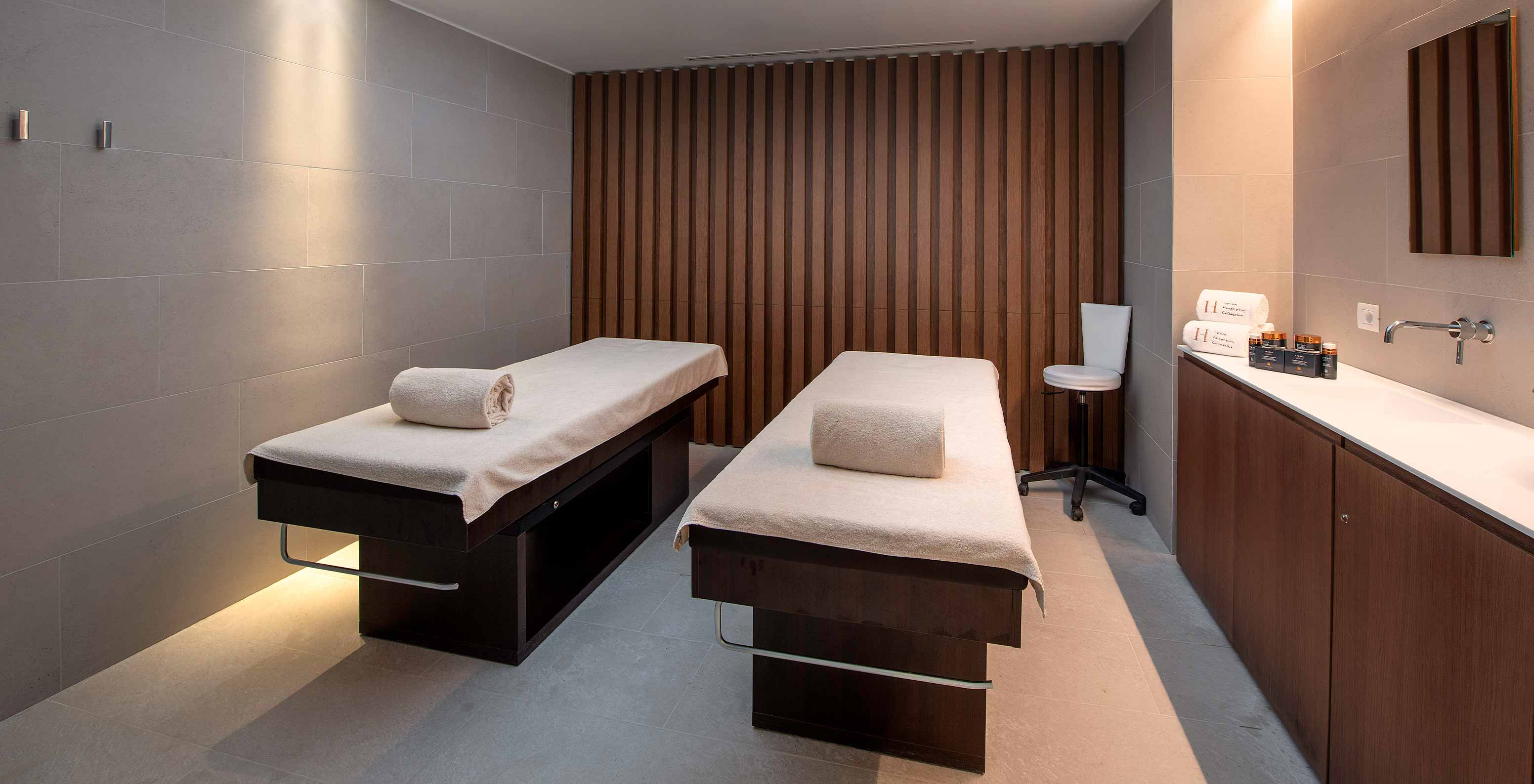 Le Massif Courmayeur, Hotel en los Alpes italianos con sala de spa y dos camillas junto a tocador de madera