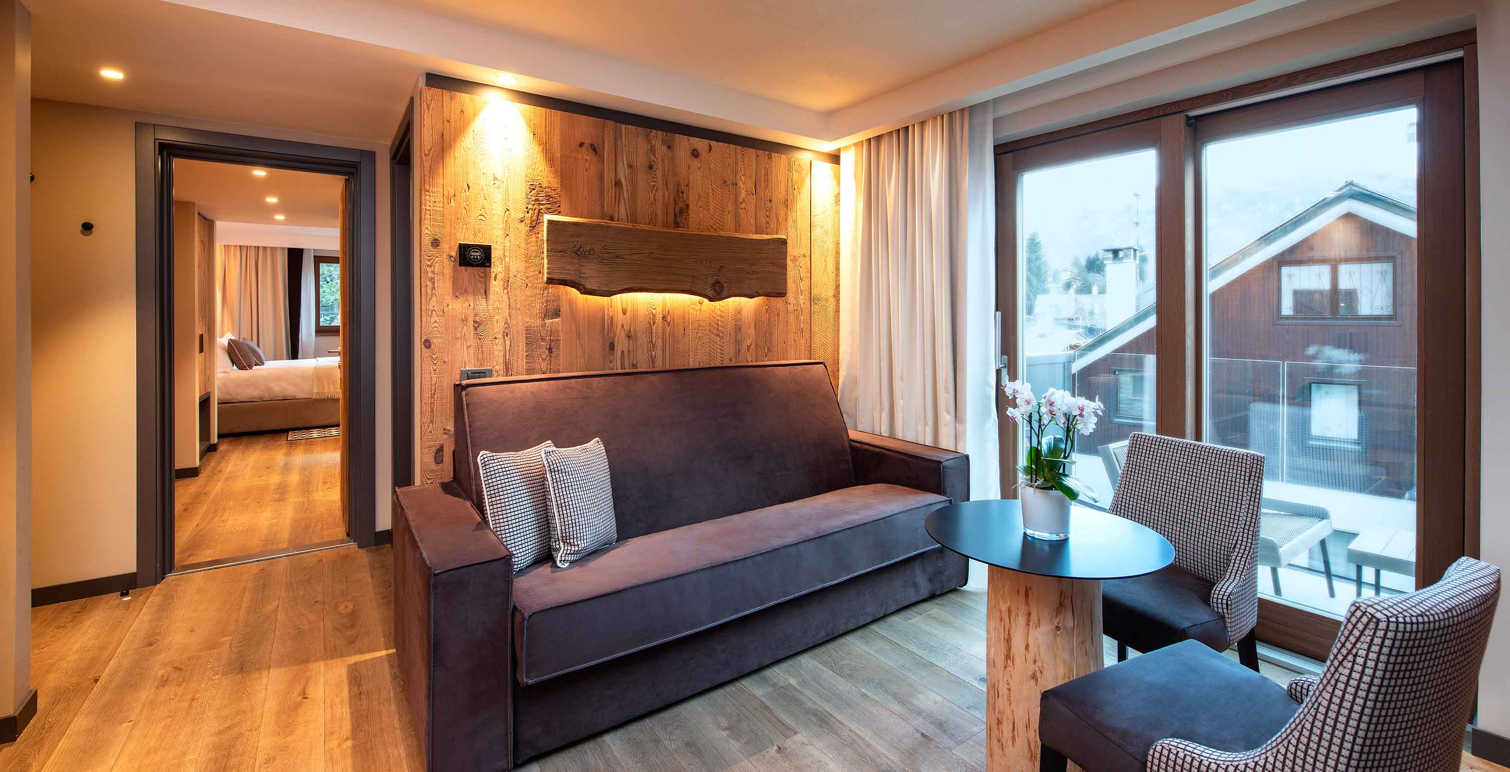 Le Massif Courmayeur, Hotel en los Alpes italianos, con sala de estar de madera y ventanales al balcón