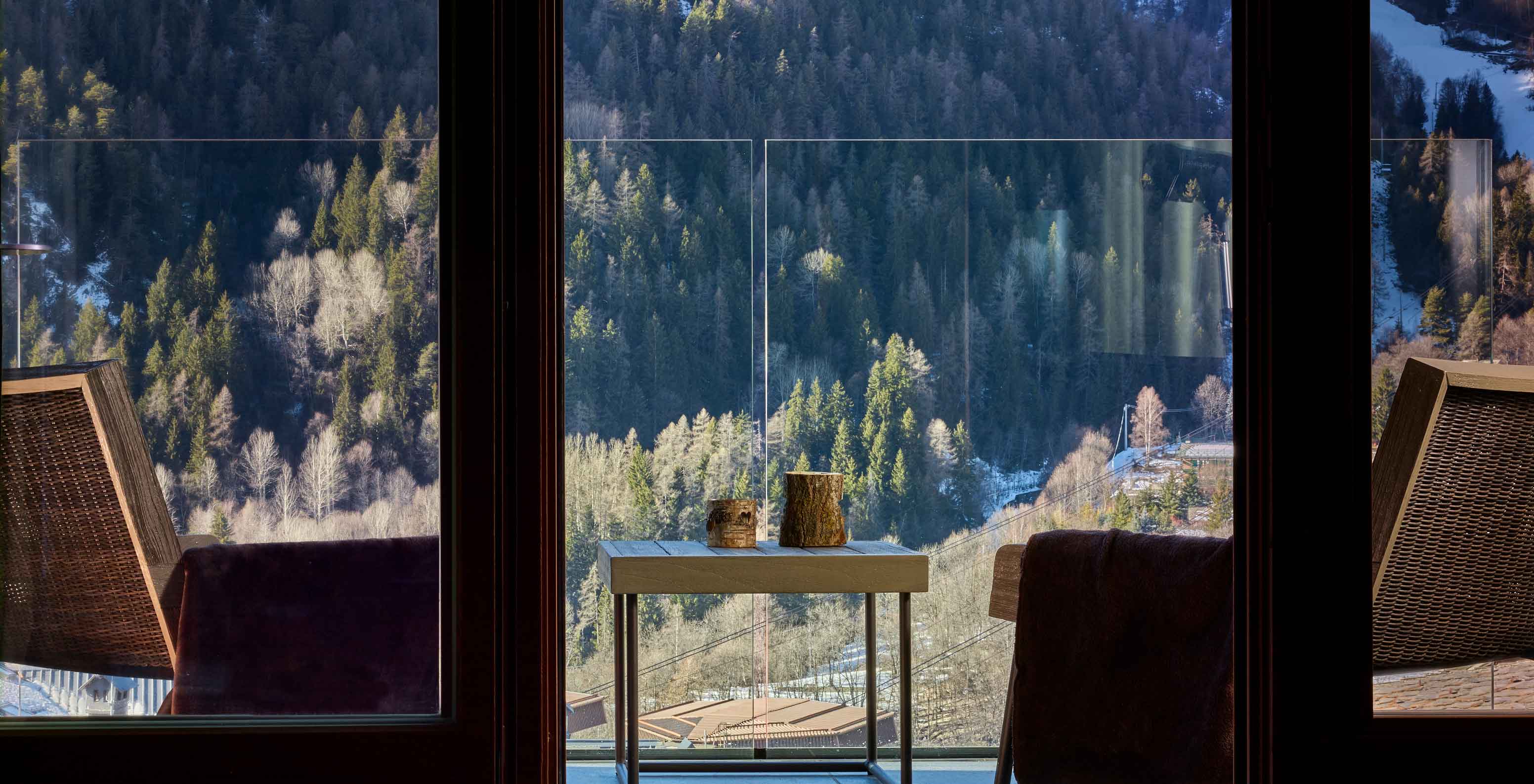 Le Massif Courmayeur, Hotel en los Alpes italianos, con vista a un balcón y bosque montañoso nevado al fondo