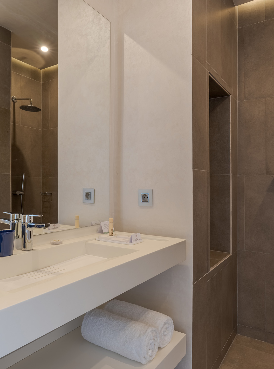 Suite Avenida CR7 en Pestana CR7 Marrakech con lavabo blanco, espejo amplio y ducha revestida en piedra