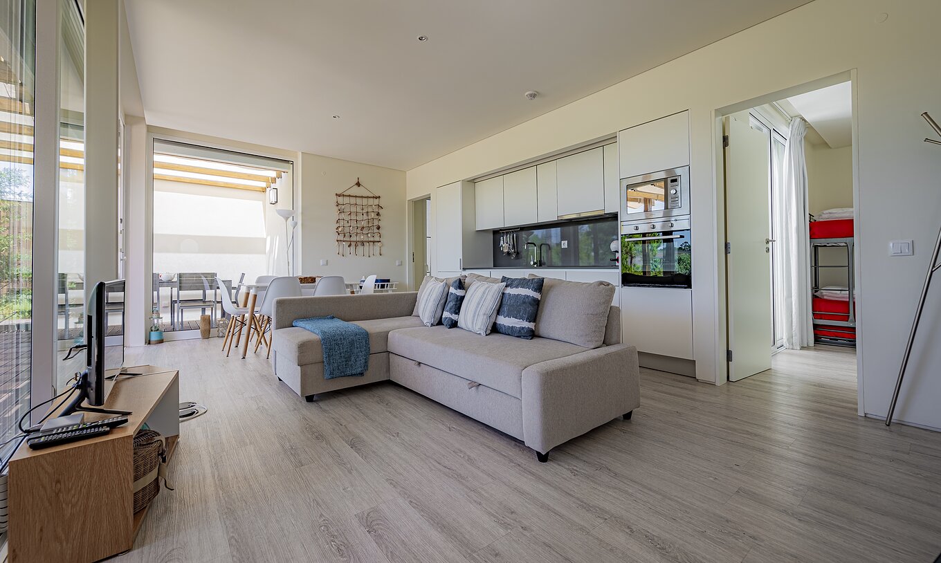 La Green Villa del Pestana Tróia Eco Resort tiene una sala junta con la cocina, sofá, mesa para cenar y televisión