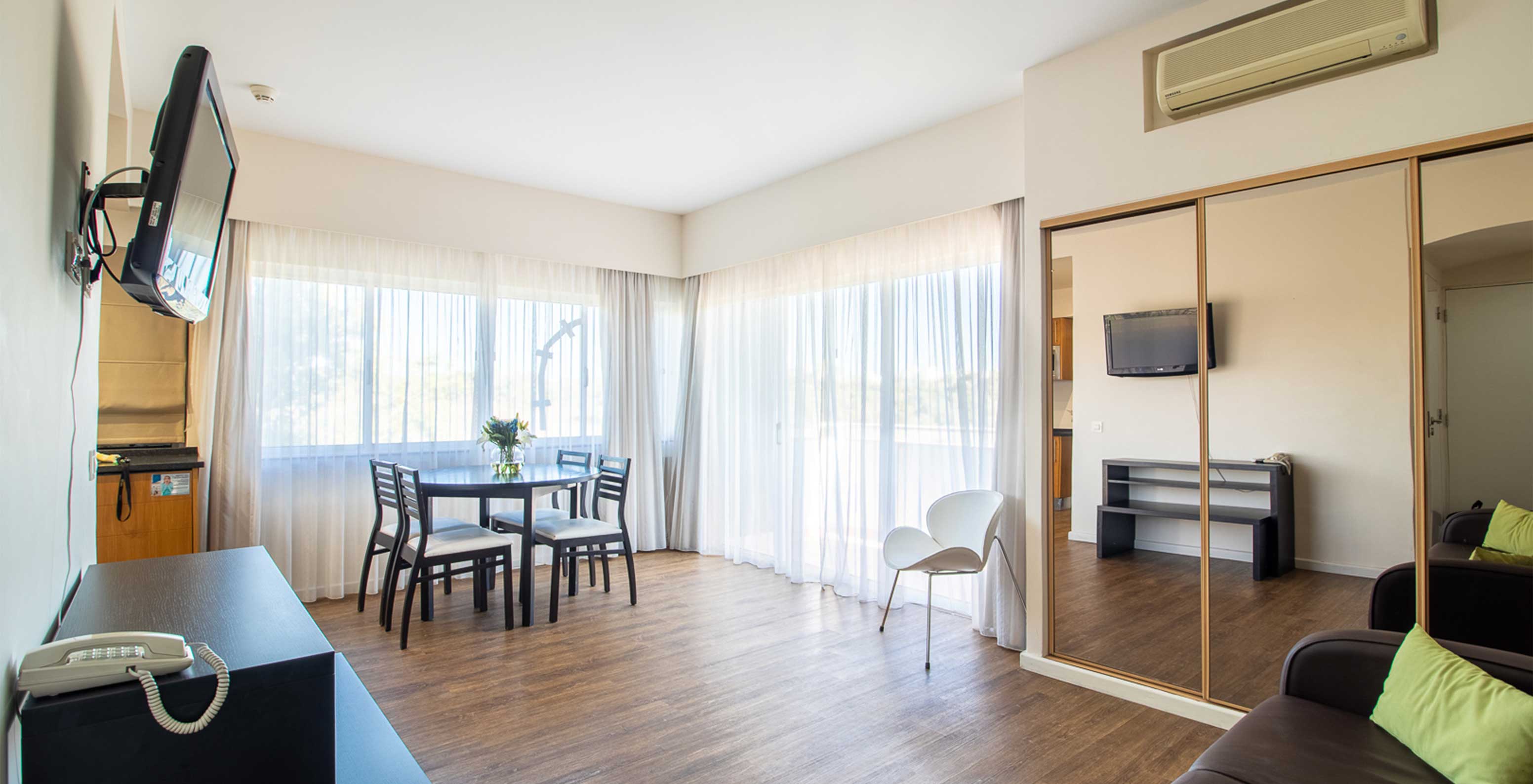 El Apartamento T1 Vista Jardín del Pestana Alvor Atlântico tiene sofá con televisión y armario con espejo