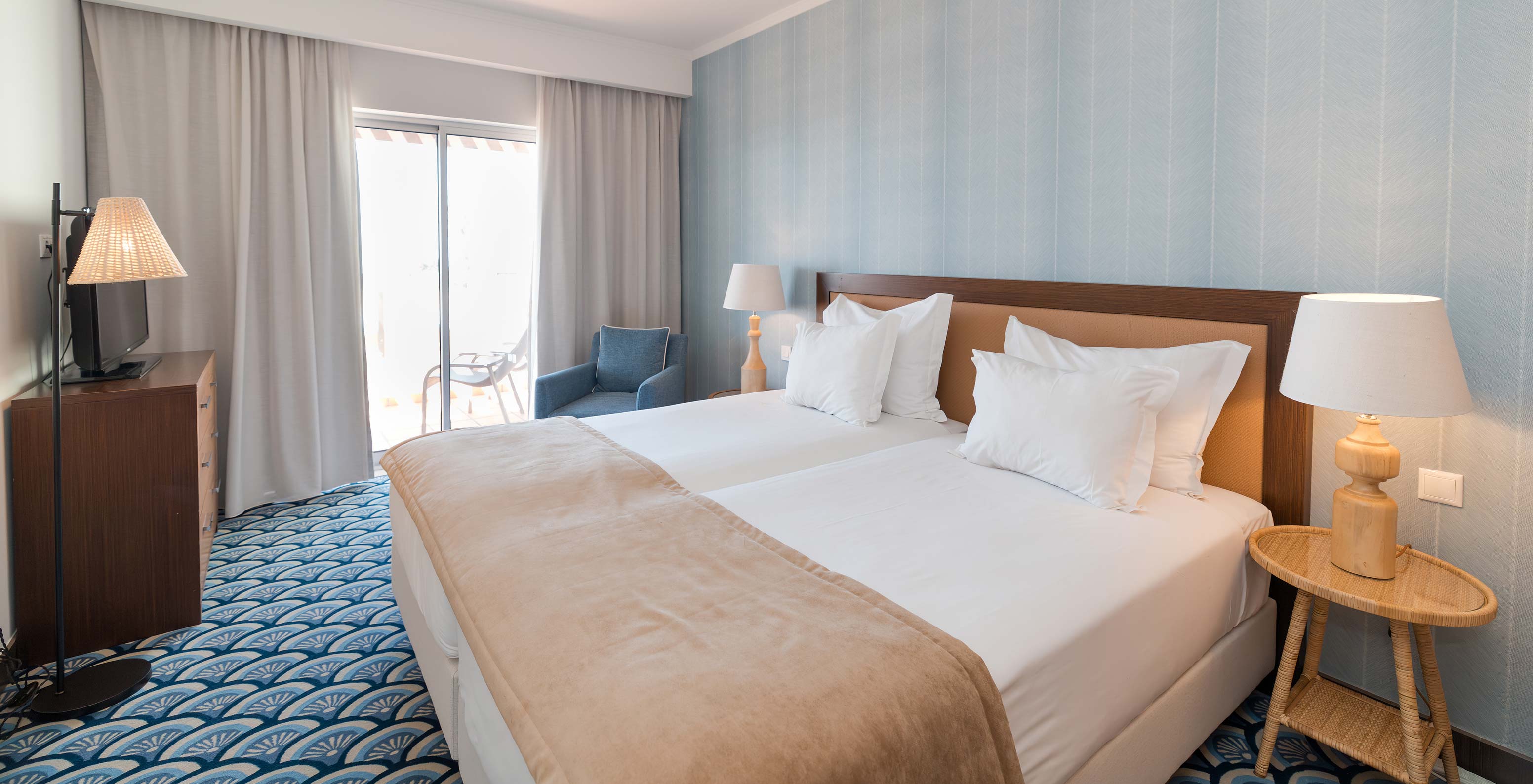 Apartamento T1 Vista Mar en Pestana Alvor Beach Villas tiene habitación con dos camas, sofá y ventana con balcón