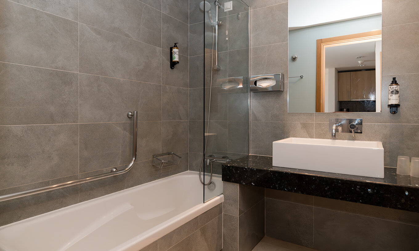 Apartamento T1 Vista Mar en Pestana Alvor Beach Villas tiene baño con bañera y lavabo con espejo