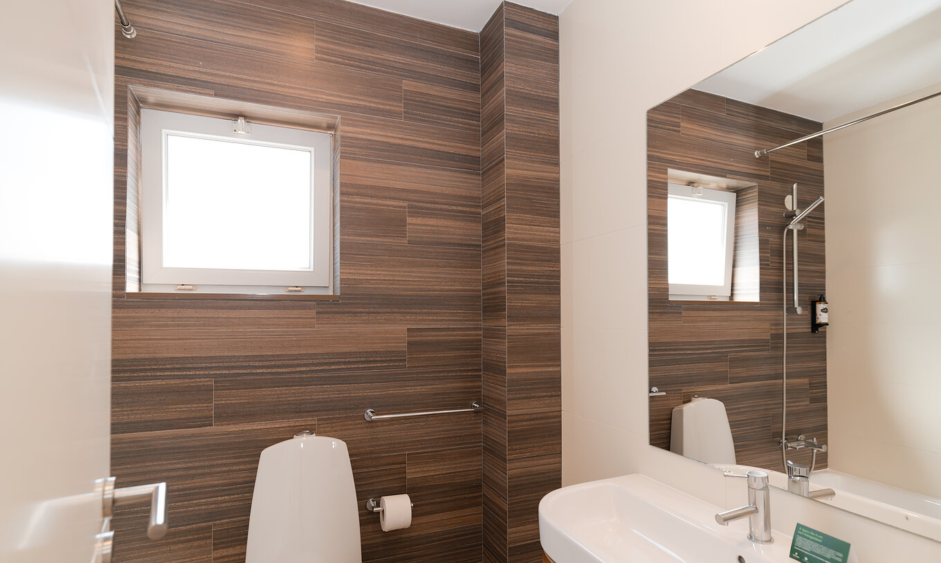 Villa 1 Habitación Vista Jardín en Pestana Alvor Beach Villas tiene un baño con lavabo, espejo y una ventana pequeña