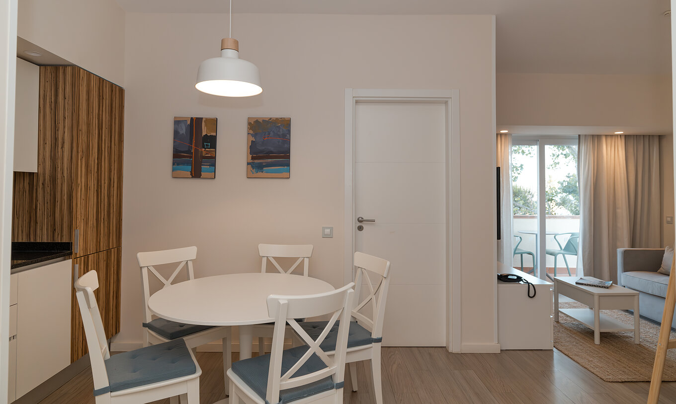 Villa 2 Habitaciones Vista Jardín en Pestana Alvor Beach Villas tiene sala con sofá, acceso al balcón y mesa de comedor