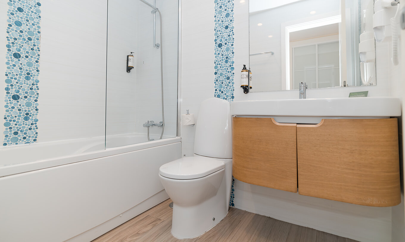 Villa 2 Habitaciones Superior Vista Jardín en Pestana Alvor Beach Villas tiene baño con bañera, lavabo y espejo