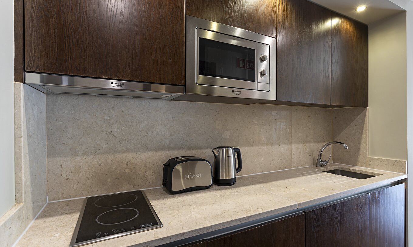 La Cliff Studio en Pestana Alvor Praia tiene una cocina equipada en madera oscura y piedra, con una estufa y un microondas