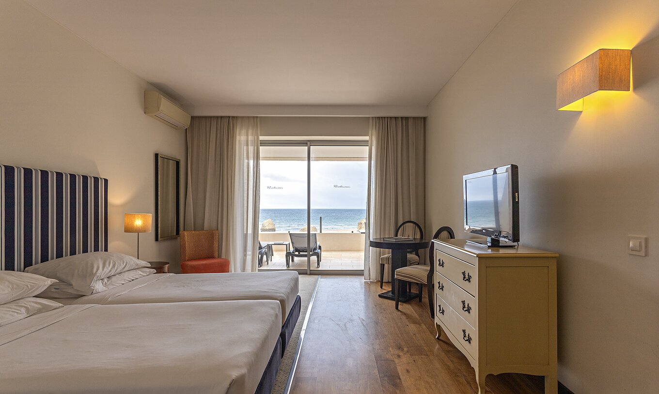La Cliff Suite T1 en Pestana Alvor Praia tiene un dormitorio doble con una cómoda, una televisión y un balcón con vistas