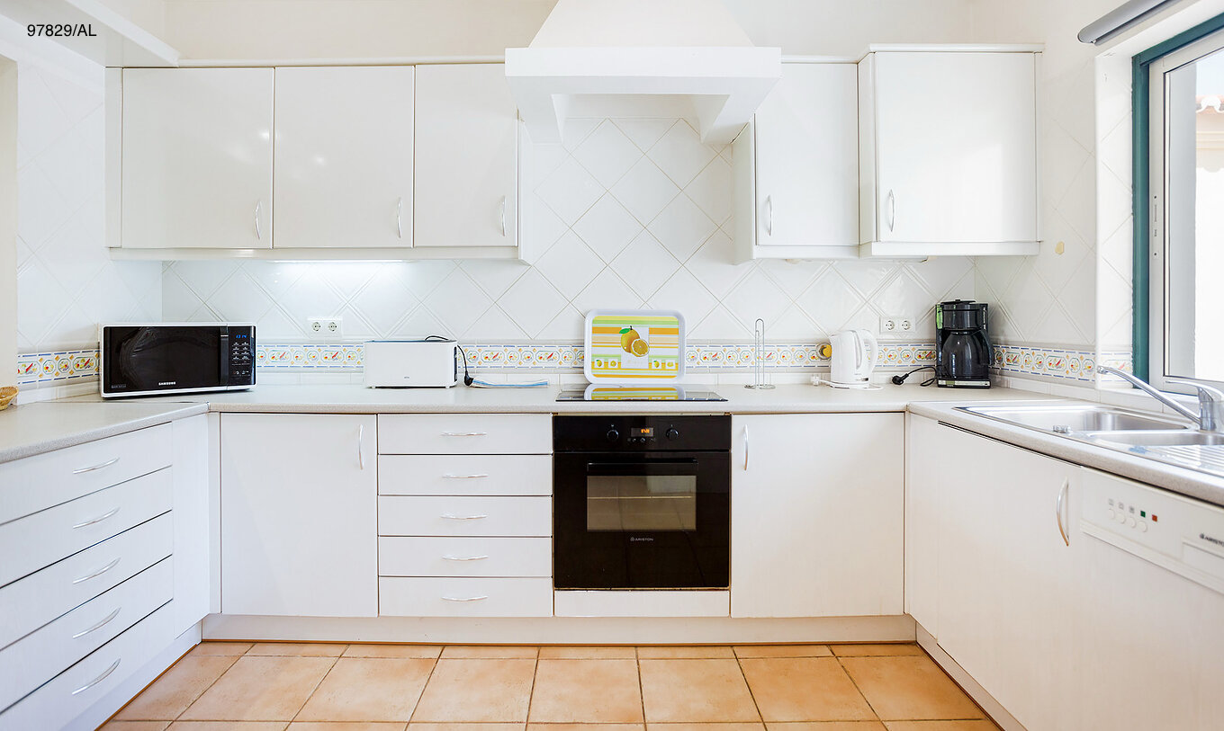 El apartamento Pestana Carvoeiro Golf T2 Estándar tiene una cocina con gabinetes blancos y una encimera