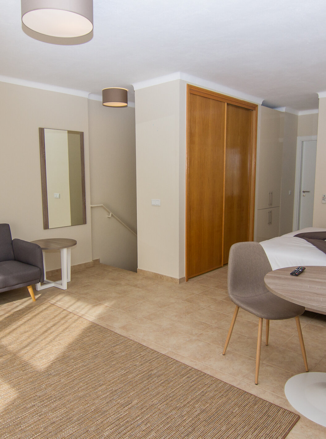 El Studio del Pestana Gramacho Residences tiene un sofá grande, una mesa y una silla, aire acondicionado y un armario