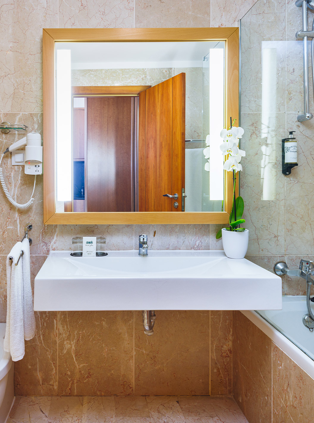 Habitación Deluxe con Vista al Jardín en Pestana Viking, baño con espejo iluminado y ducha de vidrio