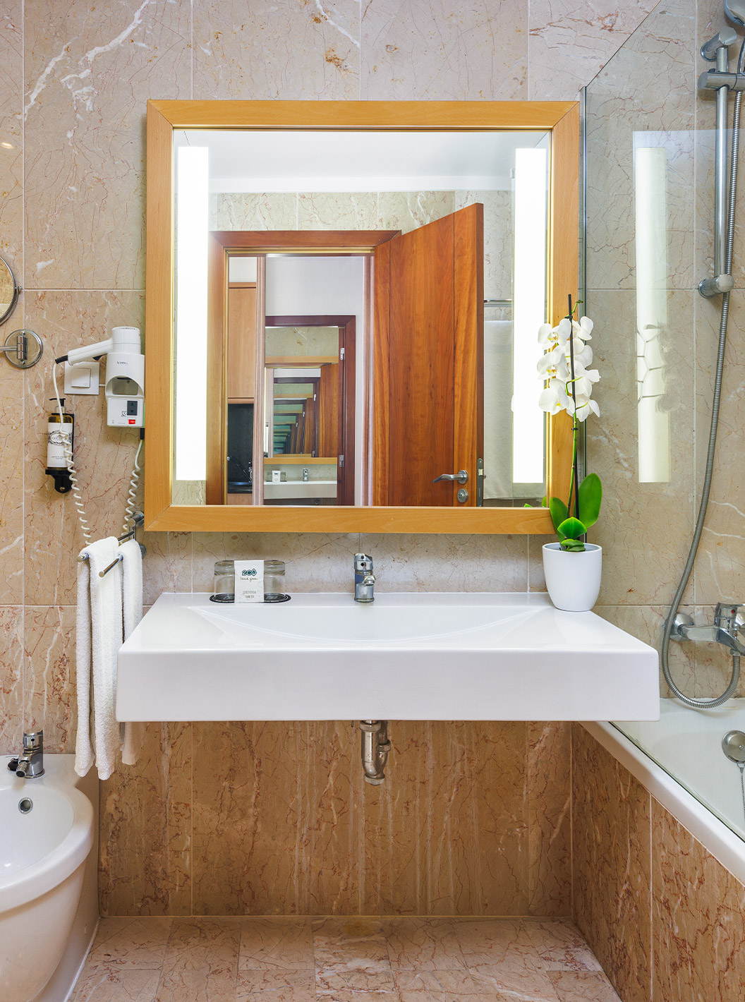 Habitación Deluxe Superior con Vista al Mar en Pestana Viking, baño con espejo iluminado y mármol beige