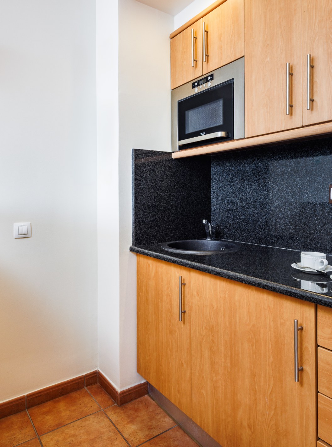 Suite Superior Vista Mar del Pestana Viking con kitchenette equipada, microondas y encimera negra iluminada