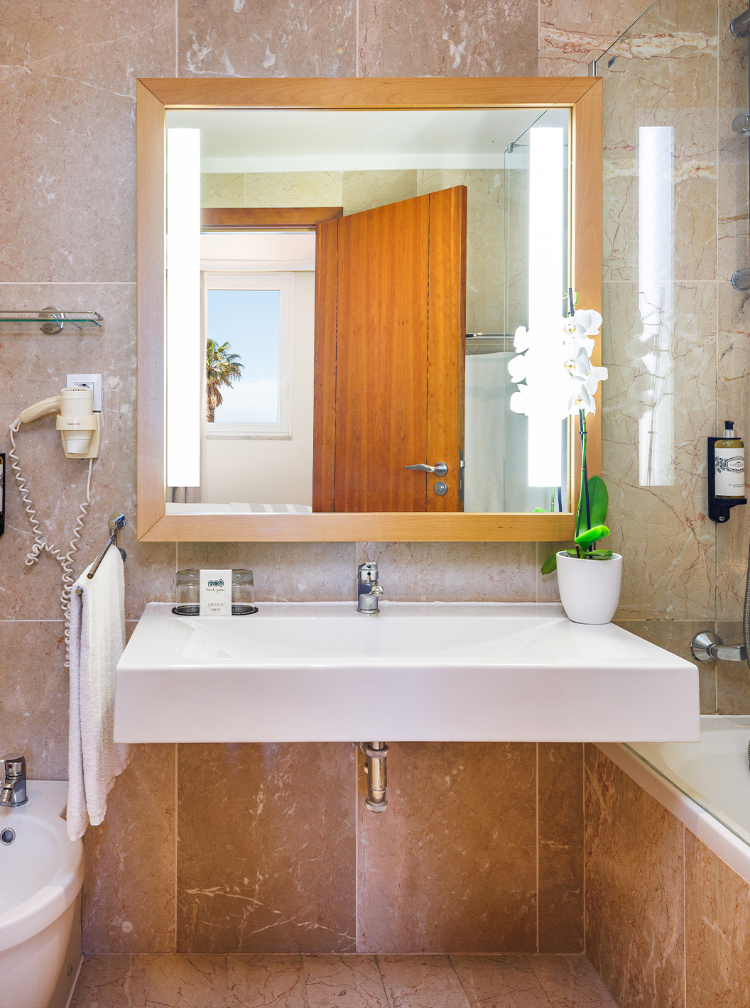 Suite T2 con vista al mar en Pestana Viking, baño con lavabo amplio, espejo iluminado y ducha de mármol