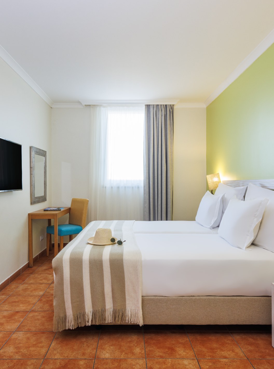 Suite en Pestana Viking con dormitorio luminoso, cama doble, escritorio de madera y televisor de pared