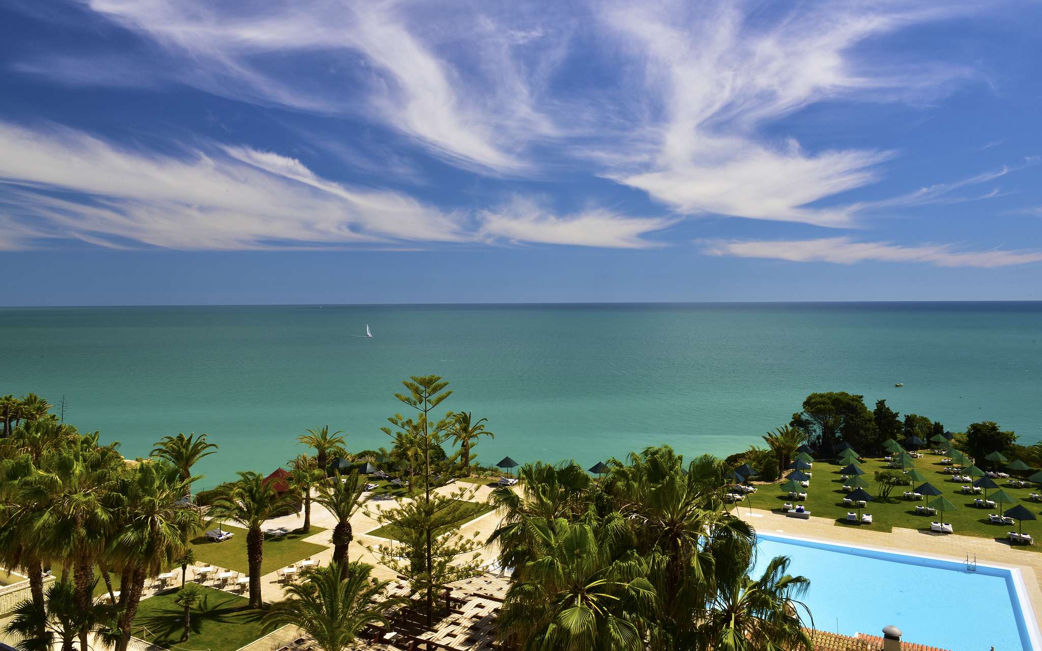Vista panorámica exterior de Pestana Viking, rodeado de palmeras alrededor de la piscina exterior, con acceso a la playa