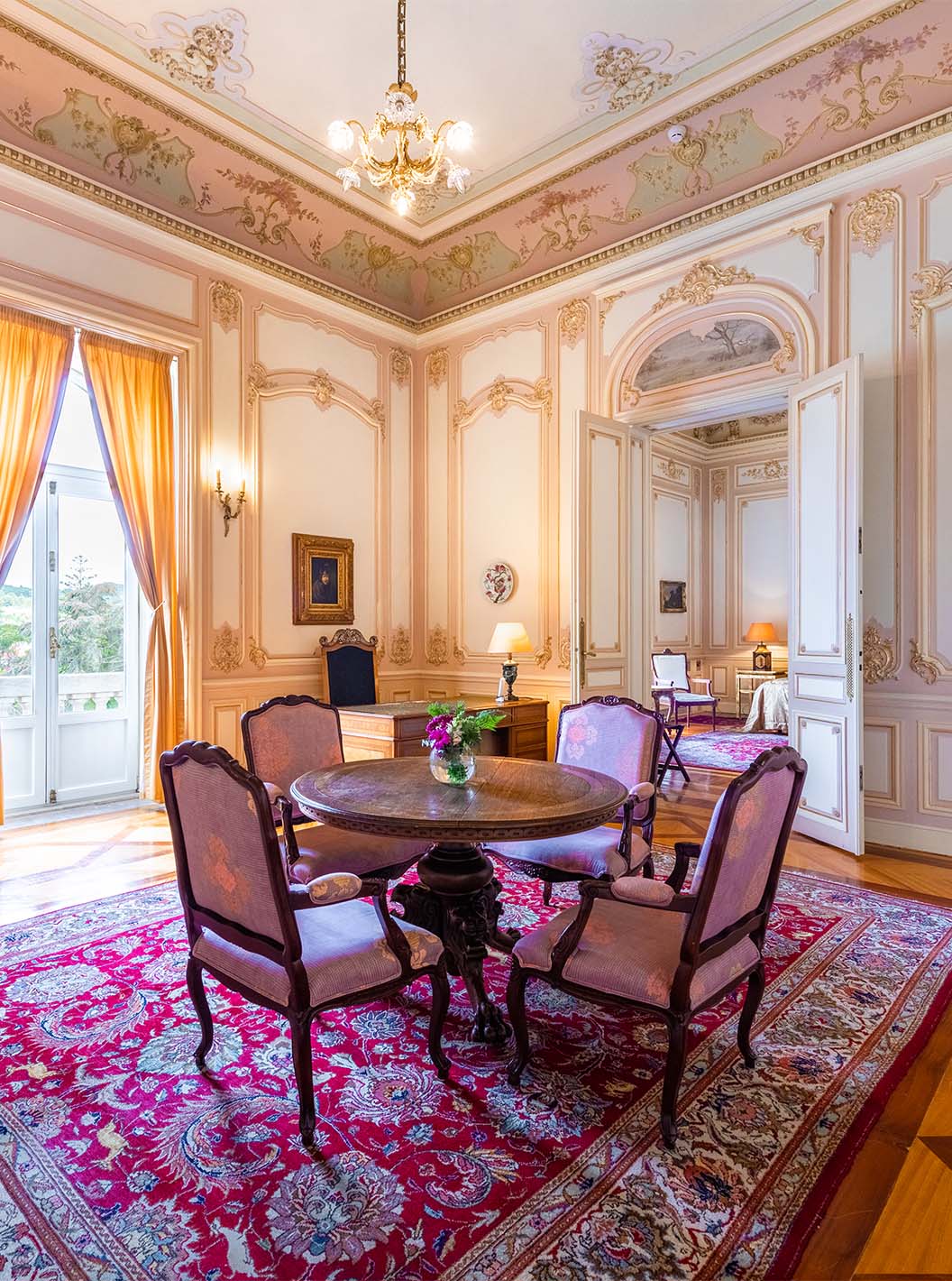 La Suite D. Carlos del Pestana Palace Lisboa tiene un salón grande y lujoso con una ventana y mesa para comidas
