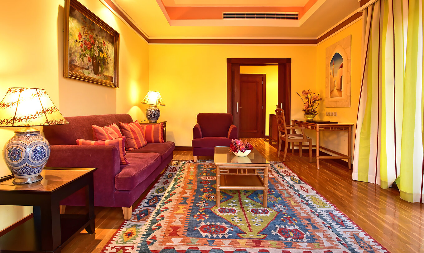 La Suite Superior del Pestana Sintra Golf tiene una sala con sofá, una poltrona y escritorio con silla