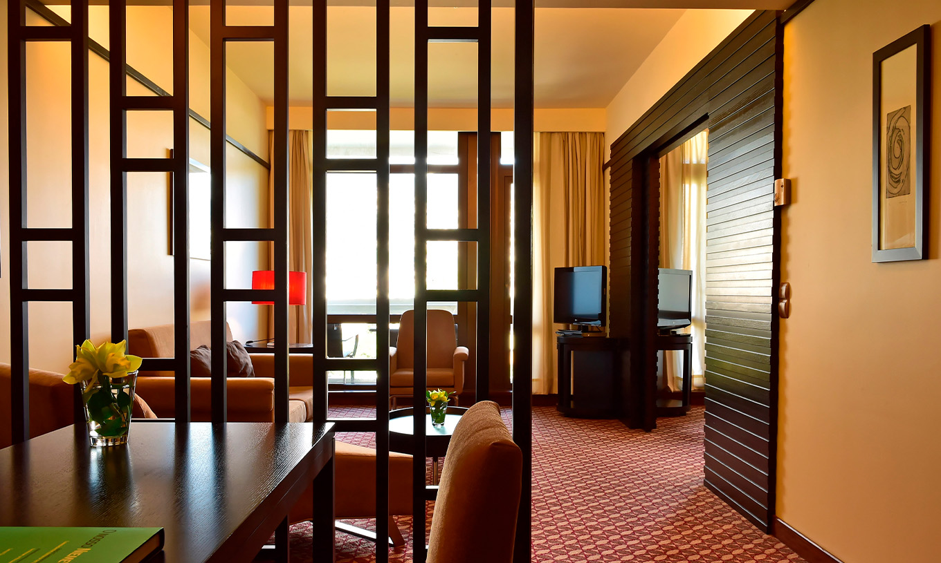 La Suite Vista Lateral Mar del Pestana Casino Park tiene zona de estar con sofá, chaise longue y mesa de apoyo