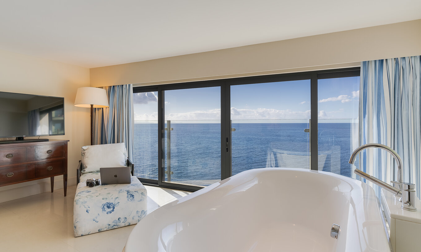 La Suite Duplex Vista Mar del Pestana Vila Lido Madeira tiene una bañera con vista al mar y una chaise longue