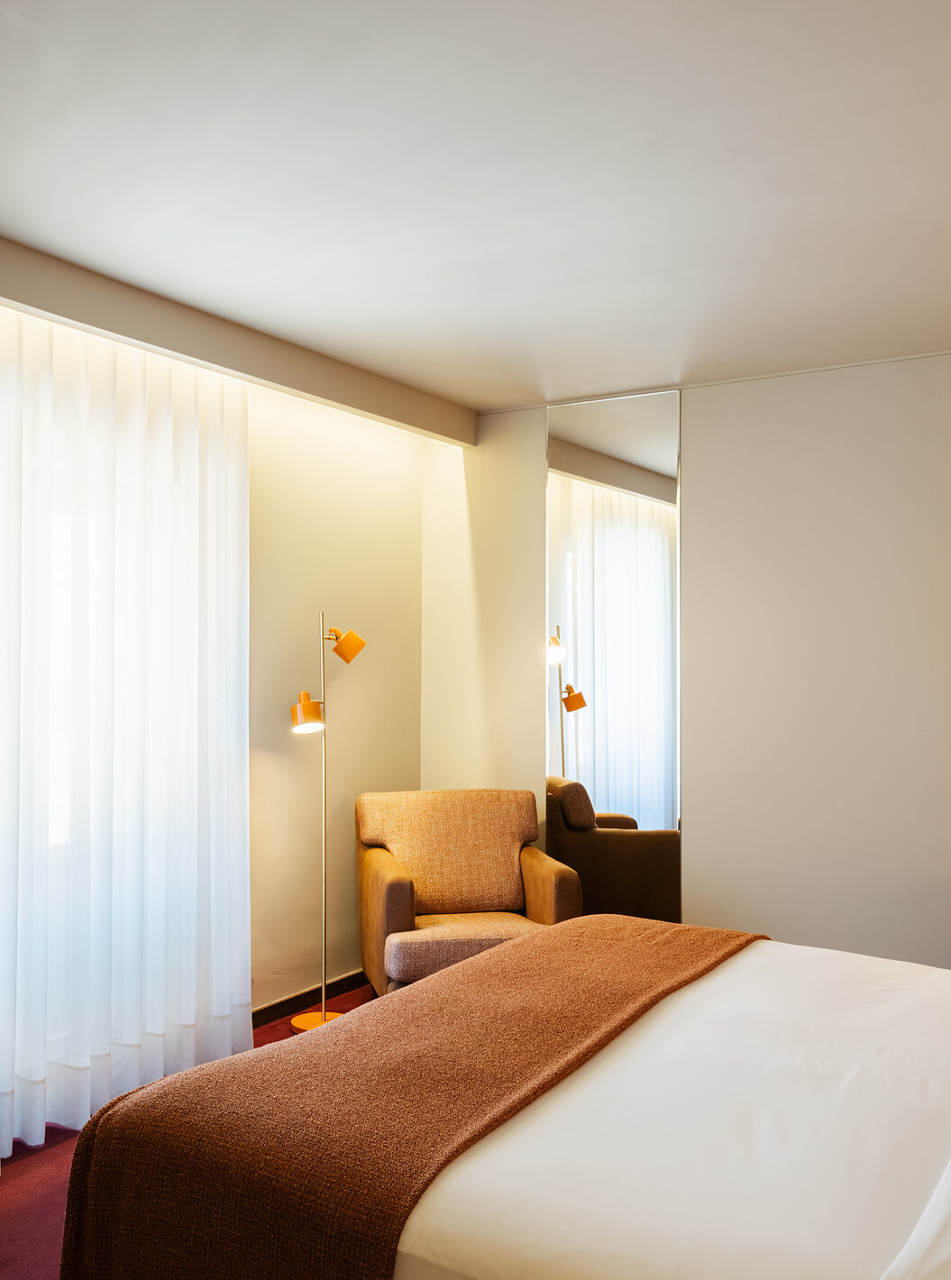 Habitación Clásica de Pestana Vintage Porto con cama blanca, sillón junto a ventana y luz cálida interior