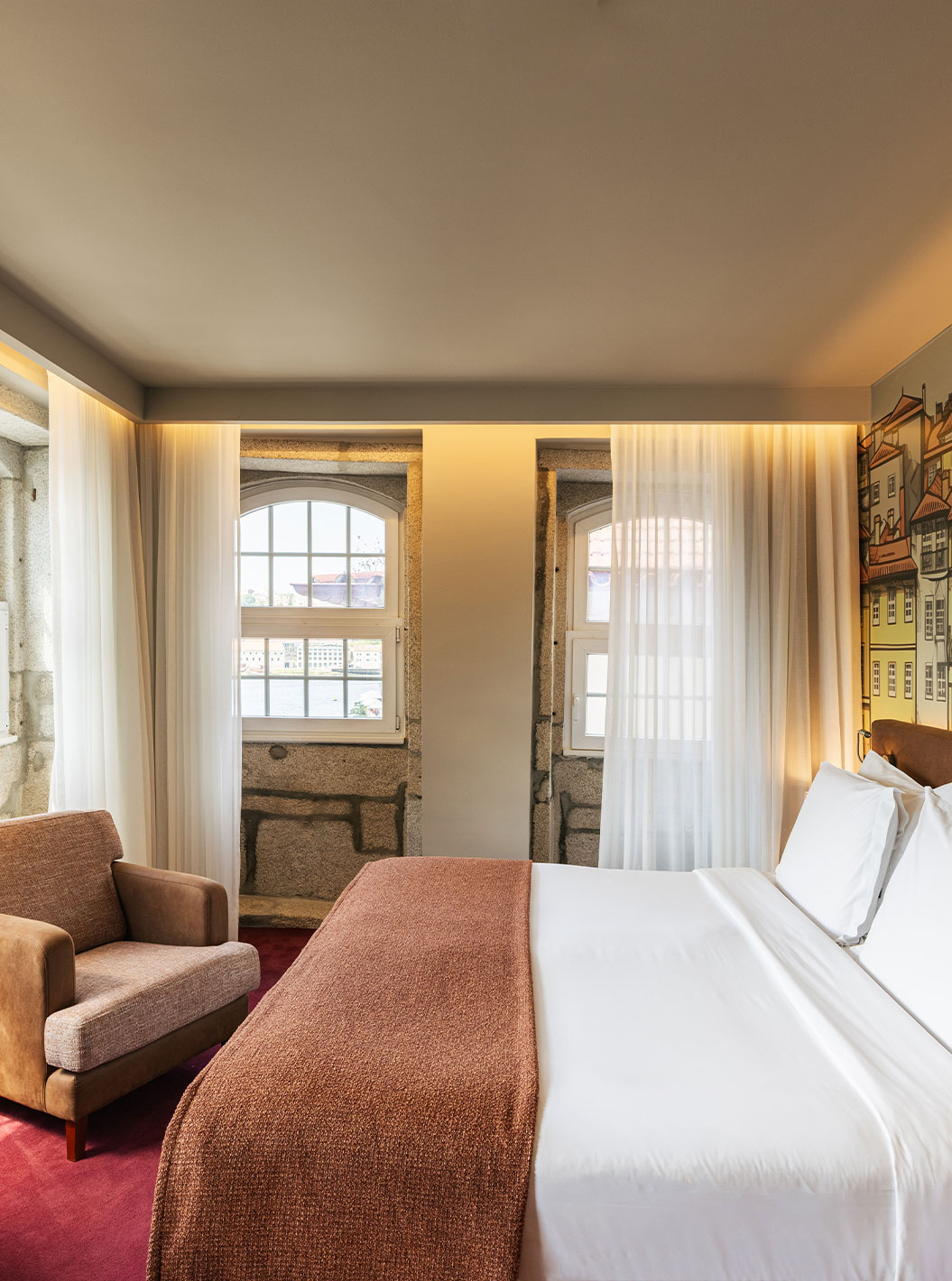 Habitación Vintage Gran Vista en Pestana Vintage Porto con cama doble, sillón y mural urbano iluminado